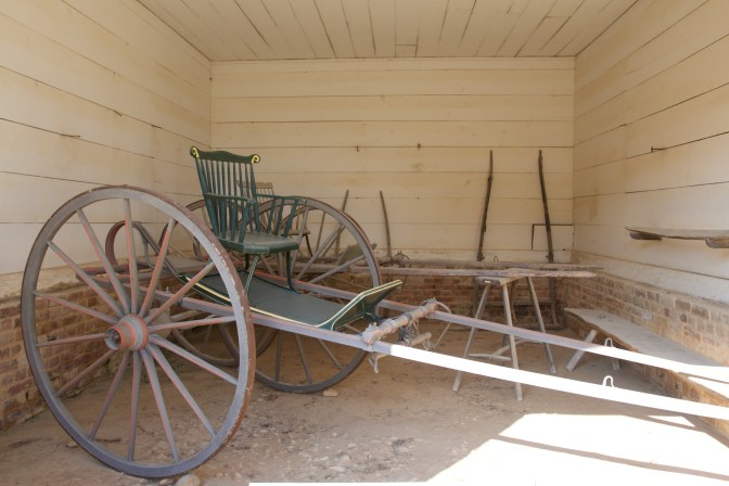 Two-wheeled cart with a chair on top of it.