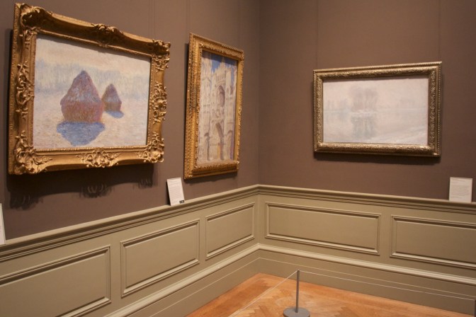 Three paintings of Money hanging on the walls.