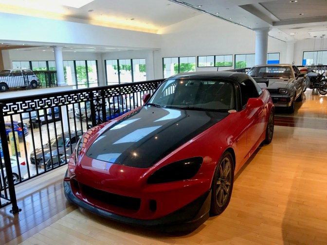 Red Honda S2000 race car, with black hood and roof.