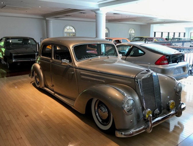 Silver Mercedes 220, with other cars in the background.