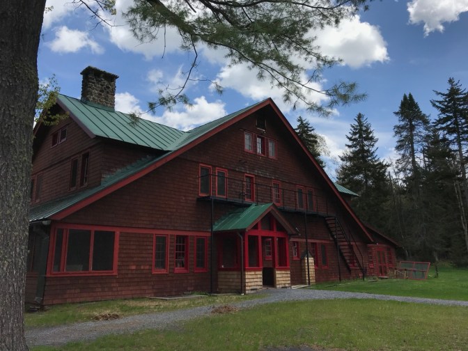 Exterior of Guest House, with a tree and a blue sky framing the photo.
