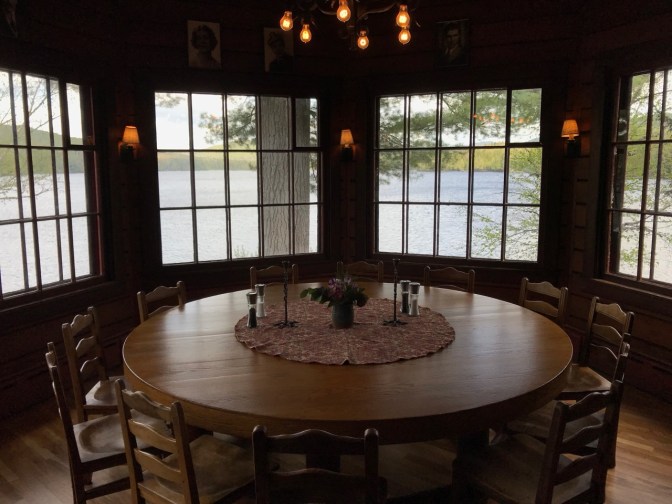 Round dining table with view of Sagamore Lake in the background.