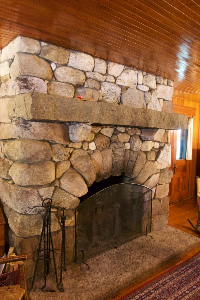 Large stone fireplace in Wigwam building.