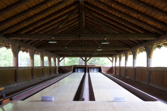 Two bowling lanes under arched roof.