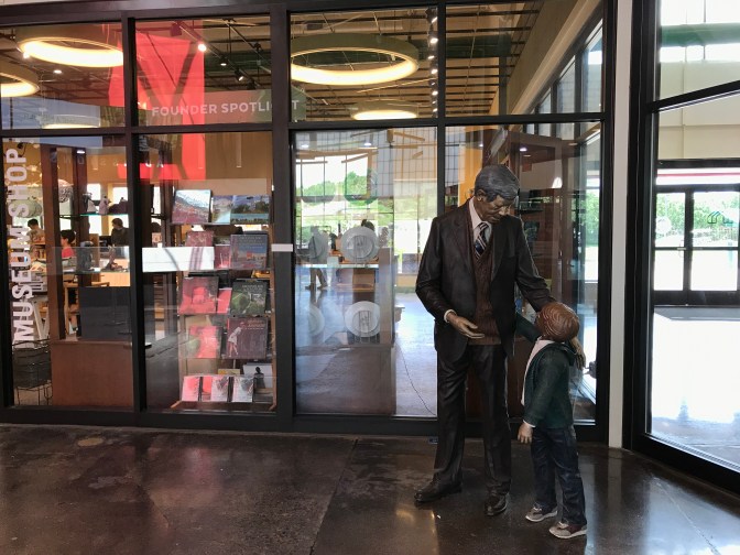 Statue of man and child standing in front of gift shop in welcome center.