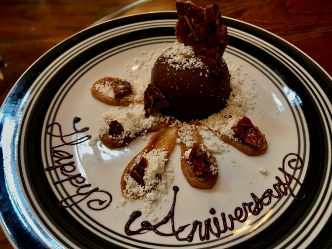 Chocolate and coconut dessert on a plate that says HAPPY ANNIVERSARY.