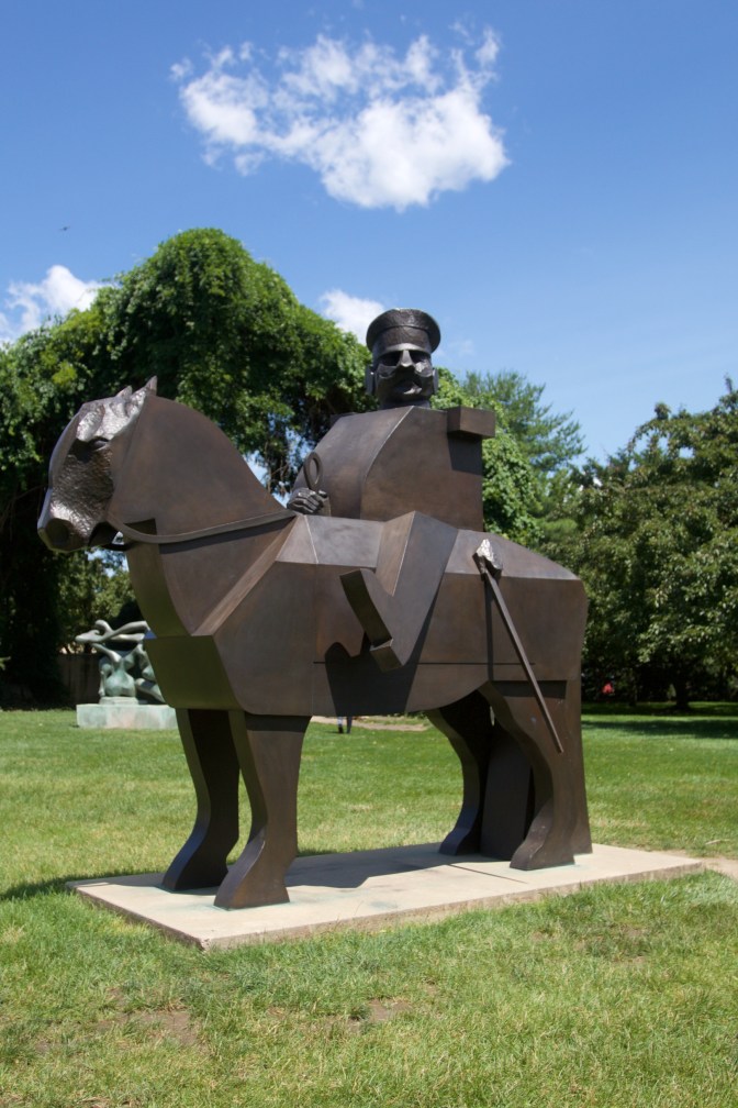 Bronze soldier riding atop horse.