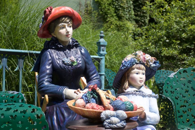 Sculpture of woman and child knitting.
