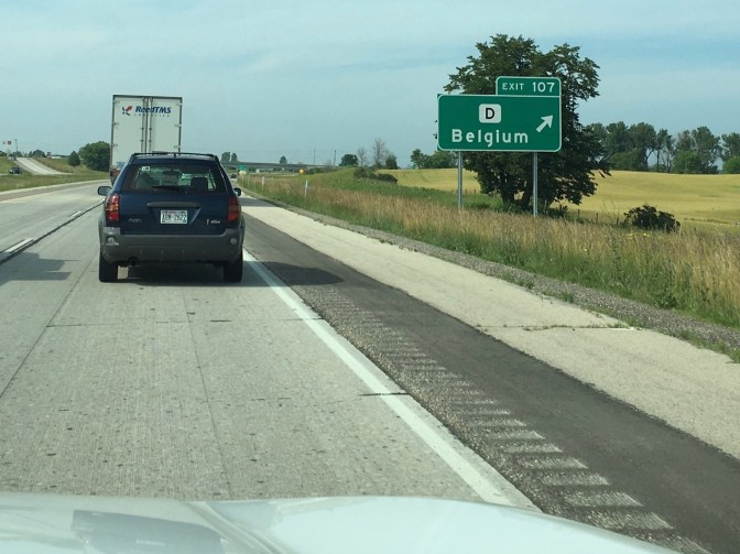Highway exit sign that reads EXIT 107 D Belgium with an arrow pointing to the right.