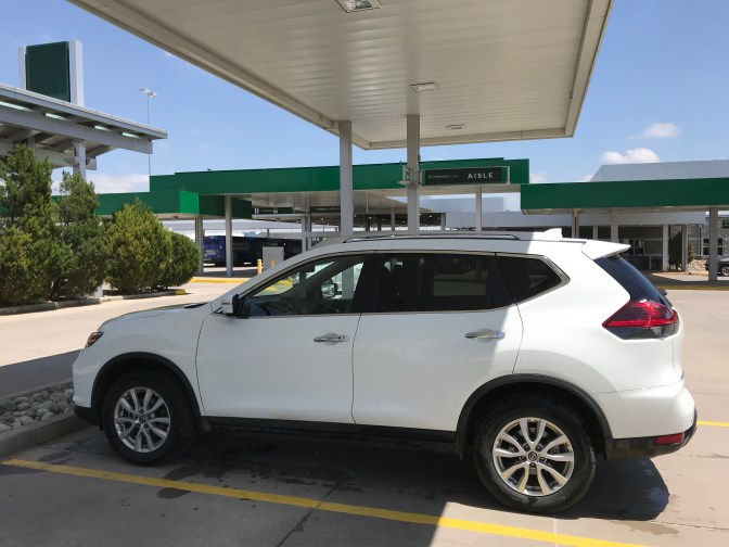 Photo of white Nissan Rogue in parking spot.