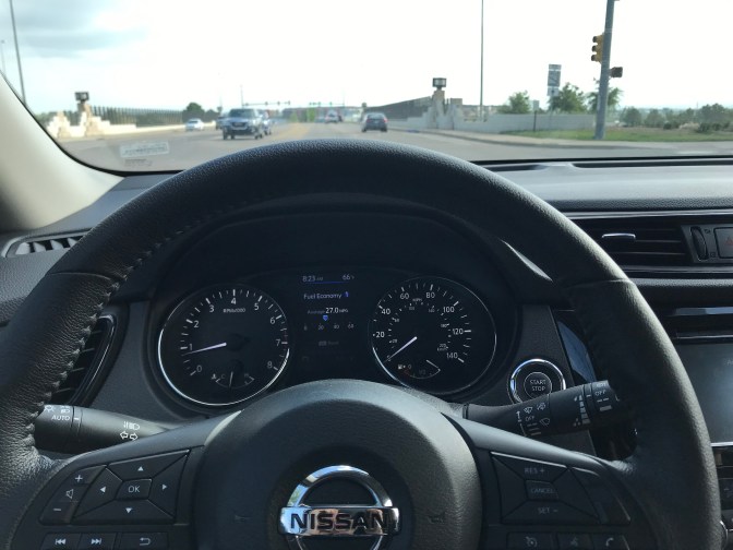 View of road behind dashboard of Nissan Rogue.