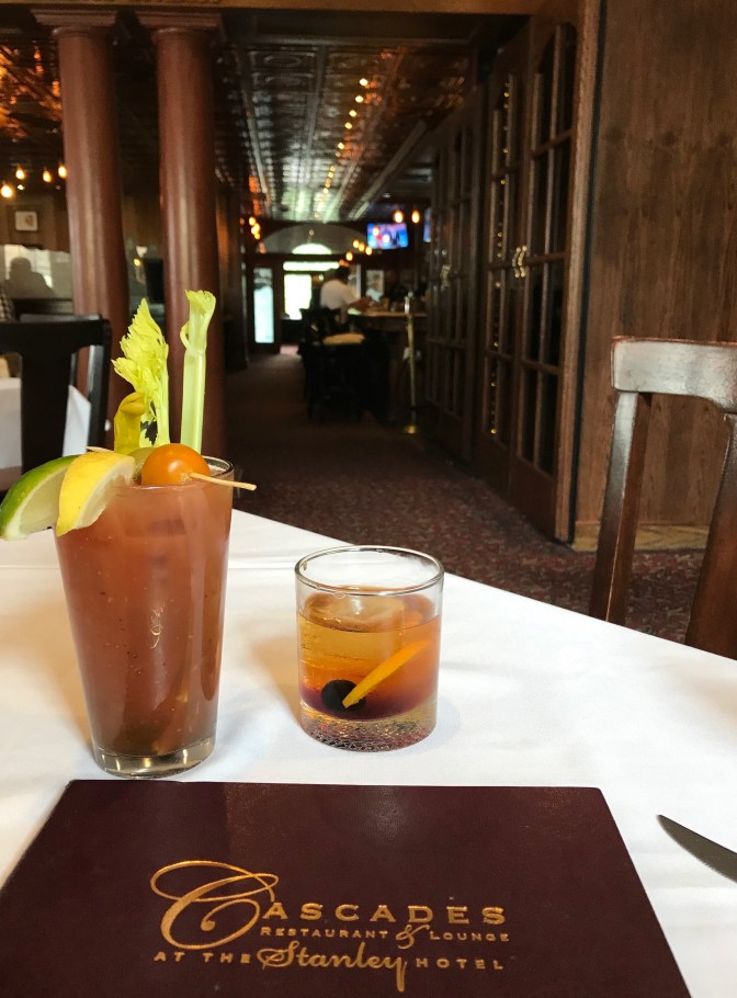Bloody Mary and Old Fashioned in front of menu for Cascades Restaurant and Bar. The hotel bar is in the background.
