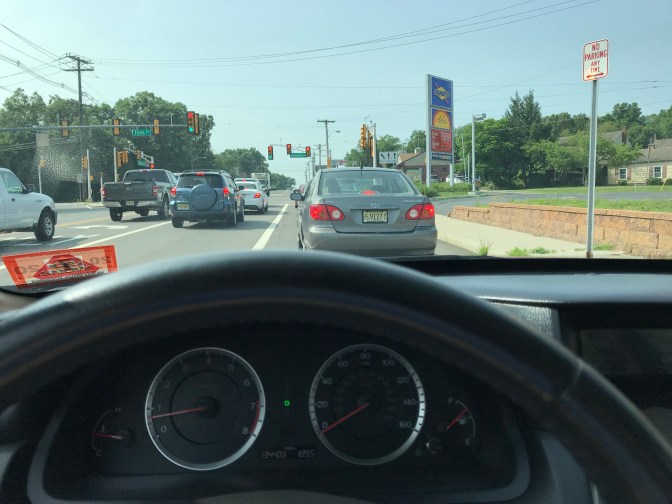 View of traffic through windshield of car.