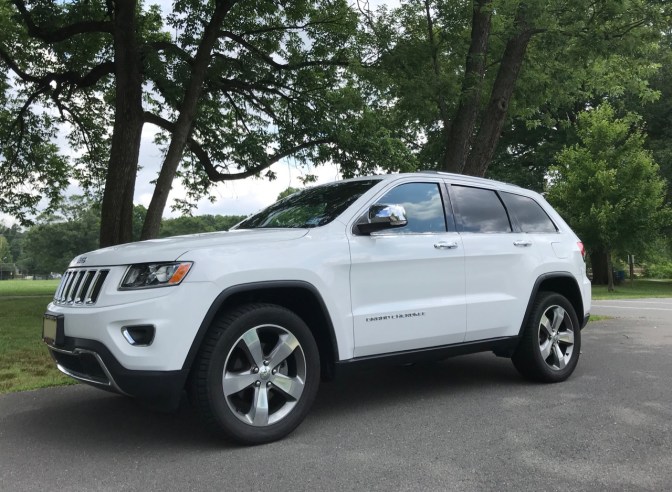 2014 Jeep Grand Cherokee, in white, parked in a park.