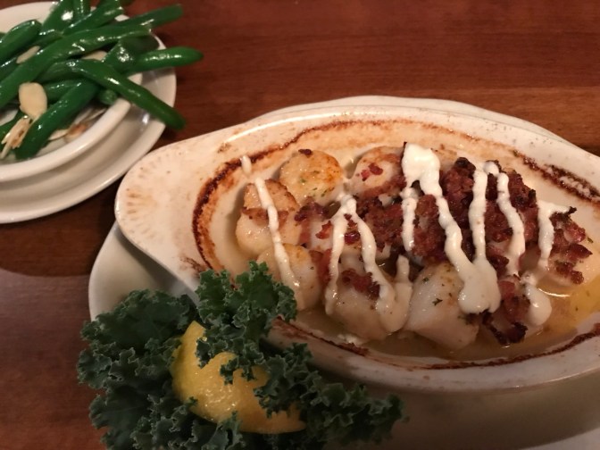 Bacon-covered scallops with green beans on separate place.