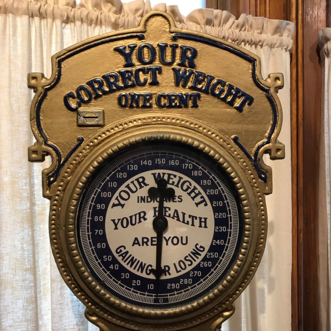 1910 Sidewalk scale for body weight. Lettering says YOUR CORRECT WEIGHT ONE CENT.