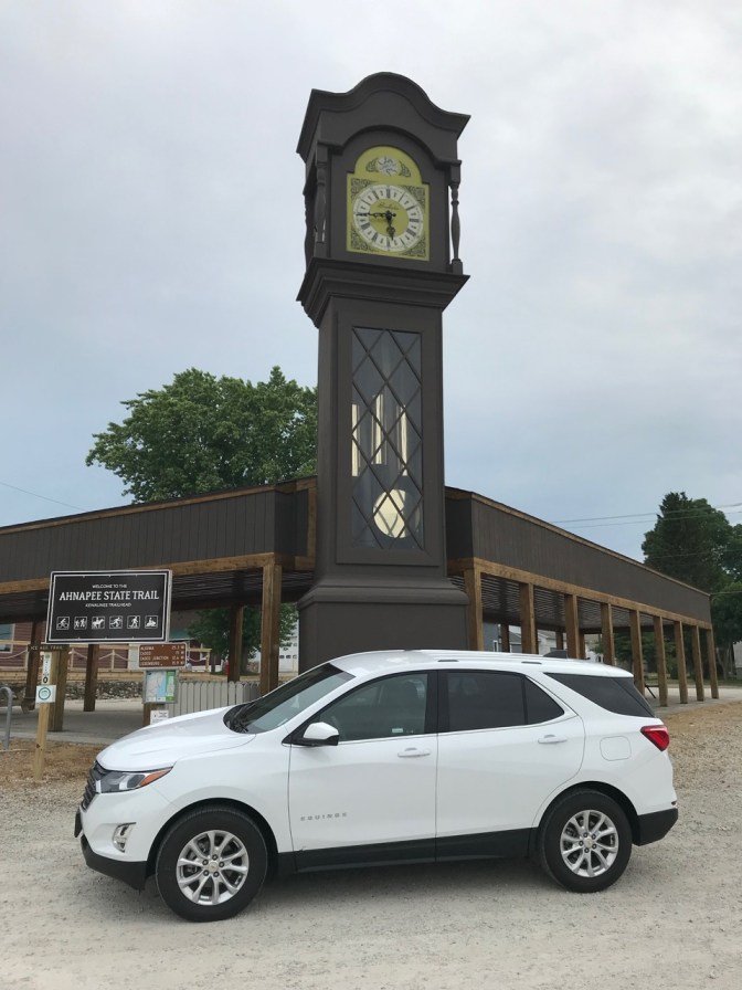 World's Tallest Grandfather Clock with Chevrolet Equinox in foreground.