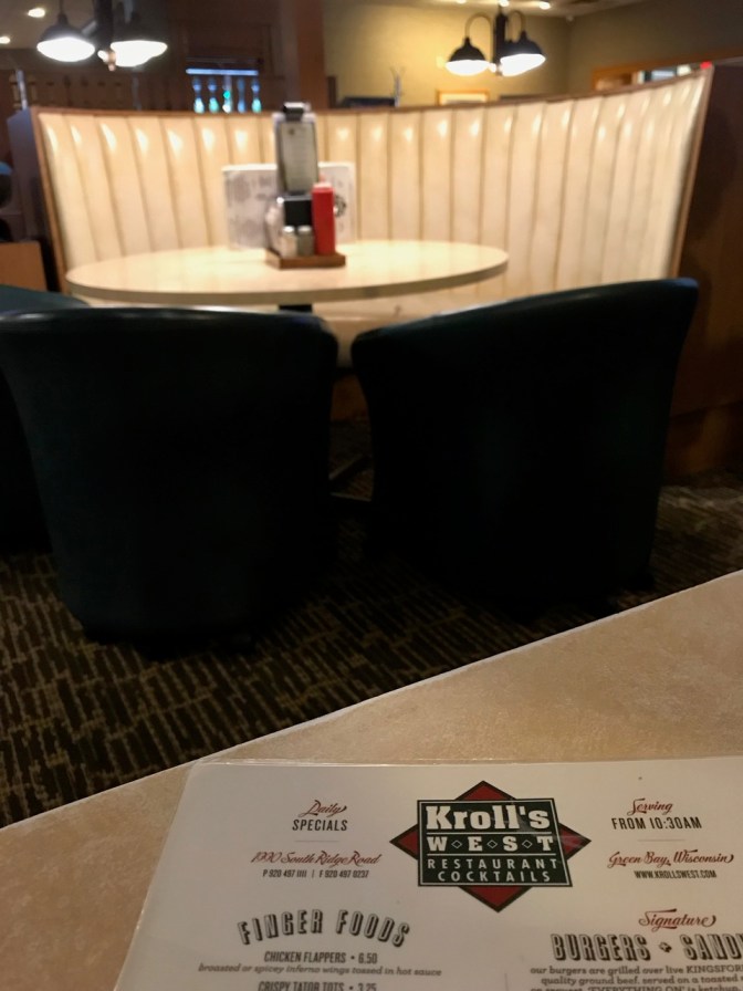 Menu of Kroll's west on table, with empty booth behind it.