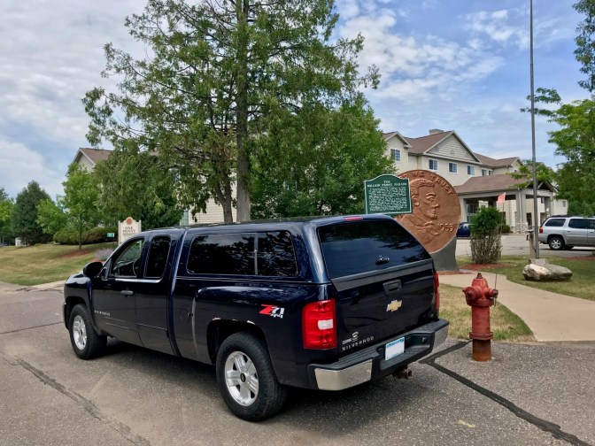Blue pickup truck in front of World's Largest Penny.