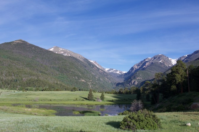 Horseshoe park, with mountains in distance, and a meadow in the foreground.