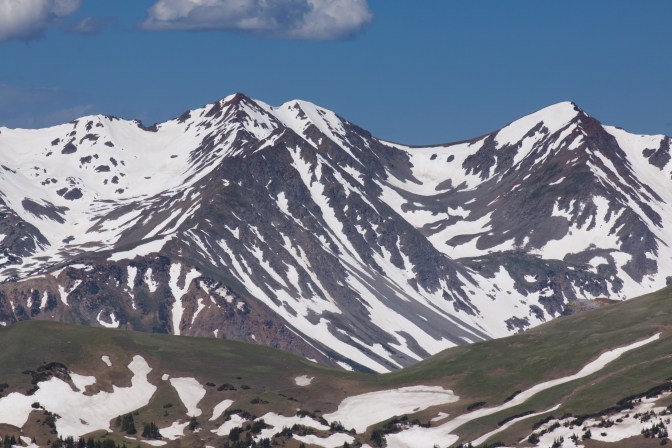View of mountains, with snow-covered hillsides in foreground.