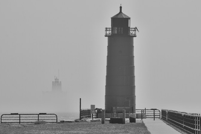 Pierhead Lighthouse in foreground, with Breakwater Light emerging from fog in distance.