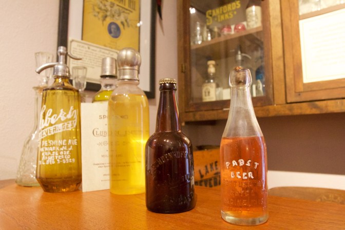 Old bottles of alcohol on speakeasy counter.