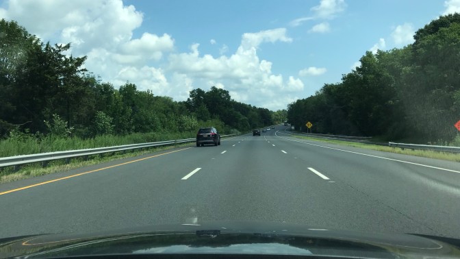 Road with cars in distance and hood of Honda Accord in foreground.