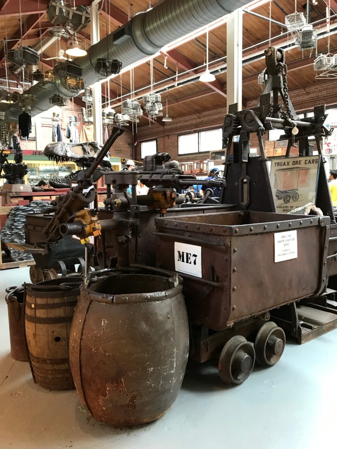 Mining equipment including barrels and mine carts, in museum.