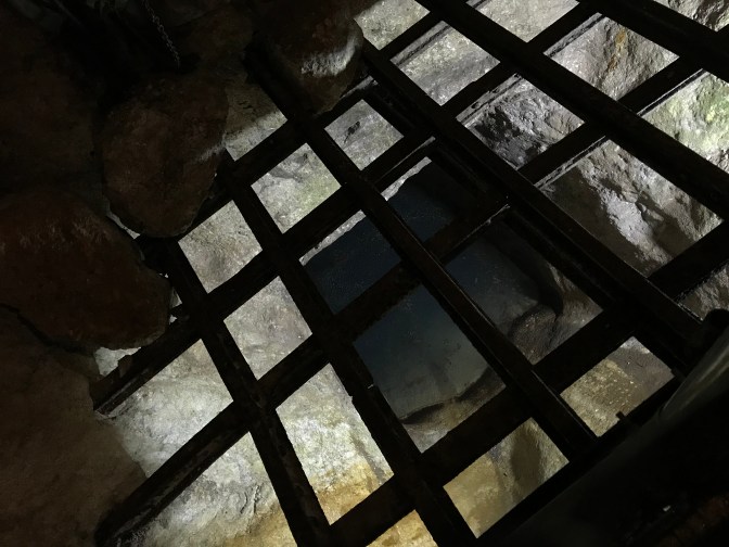 Metal grate with mine shaft beneath it.