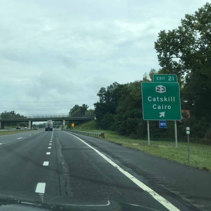 Roadside sign beside highway that says EXIT 21 23 CATSKILL CAIRO
