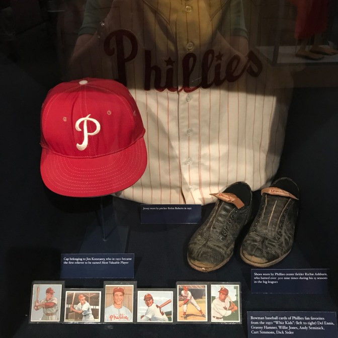 Baseball cards, cleats, cap, and jersey from 1950 Philadelphia Phillies Whiz Kids team.