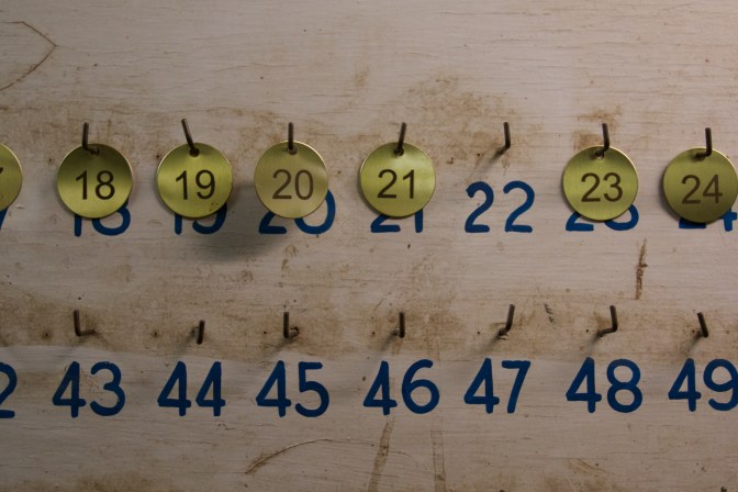 Brass miners tags on wooden board.