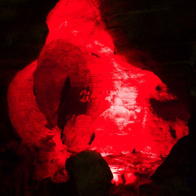 Small rock chamber lit by red light.