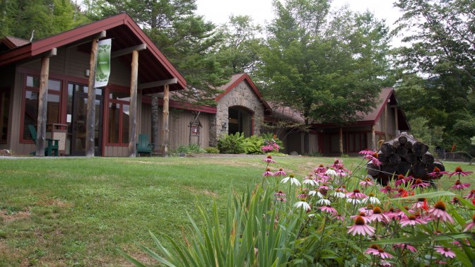 Museum building with steepled roof. Flowers are in the foreground.