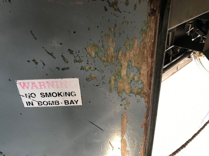 Sign on door that says WARNING NO SMOKING IN BOMB BAY.