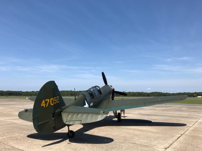 Curtiss P-40 Warhawk fighter on tarmac of museum.