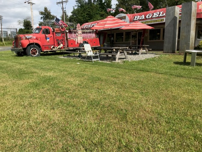Exterior of Firehouse Bagels with a fire engine in front of bagel shop.
