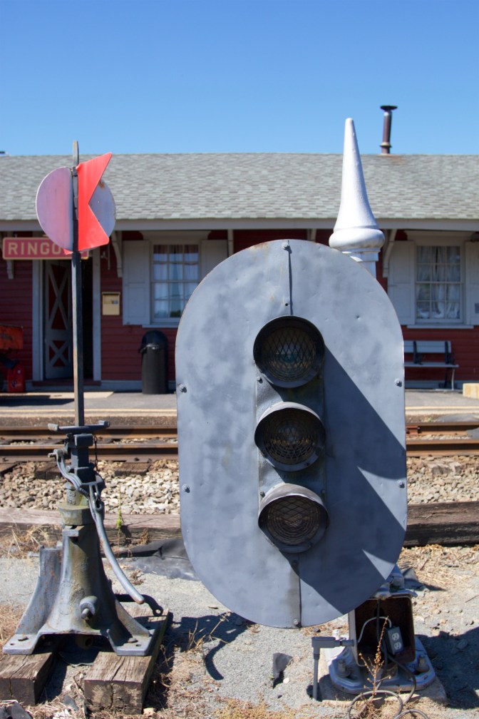 Train signal and stand in front of station.