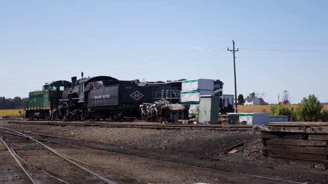 Train locomotives in train yard, being repaired.