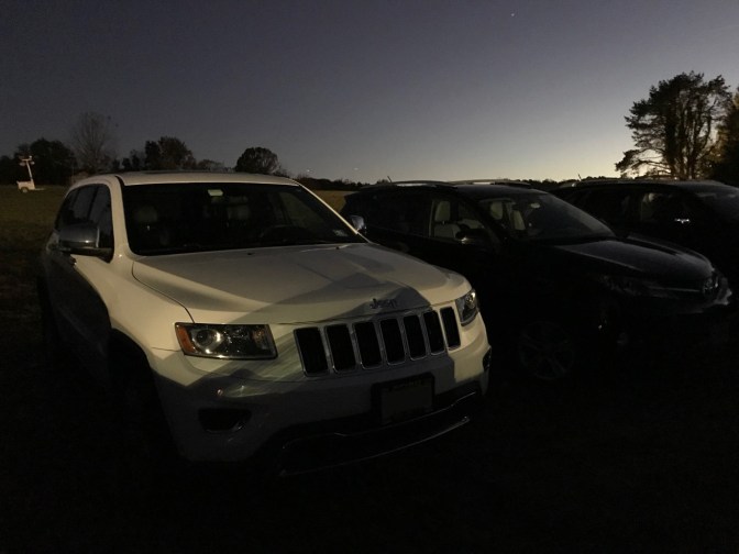 2014 Jeep Grand Cherokee parked in field at dusk.