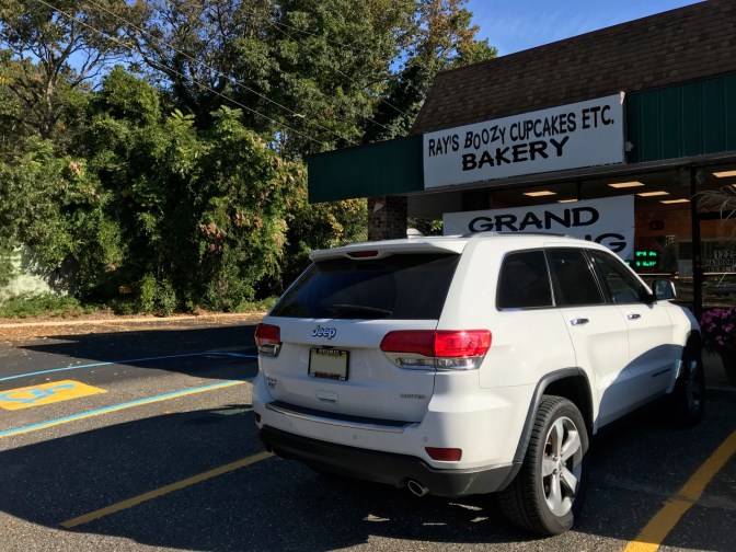 2014 Jeep Grand Cherokee parked in front of strip mall. Sign above door says RAY'S BOOZY CUPCAKES ETC. BAKERY.