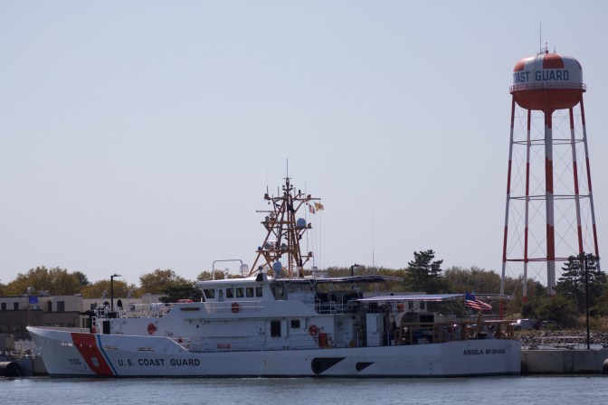 USCG cutter docked in front of Coast Guard water tower.