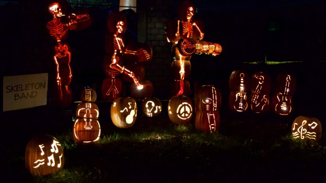 Skeletons playing instruments, carved out of pumpkins.