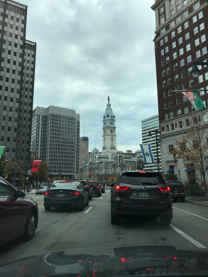View of Philadelphia's City Hall beyond a line of traffic.