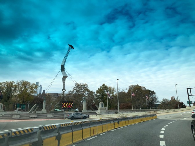 Stainless steel sculpture of a lightning bolt striking a key.