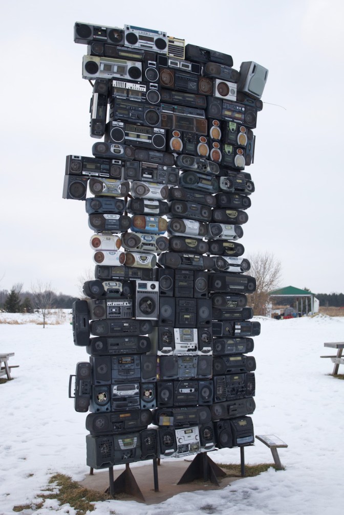 3 stacks of AM/FM/Tape boom boxes, each stack with approximately 22-23 boomboxes per stack.