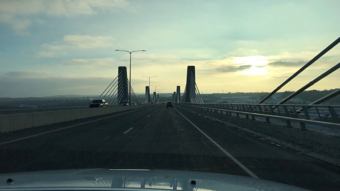 Car crossing St. Croix Crossing bridge with sunlight in the sky.