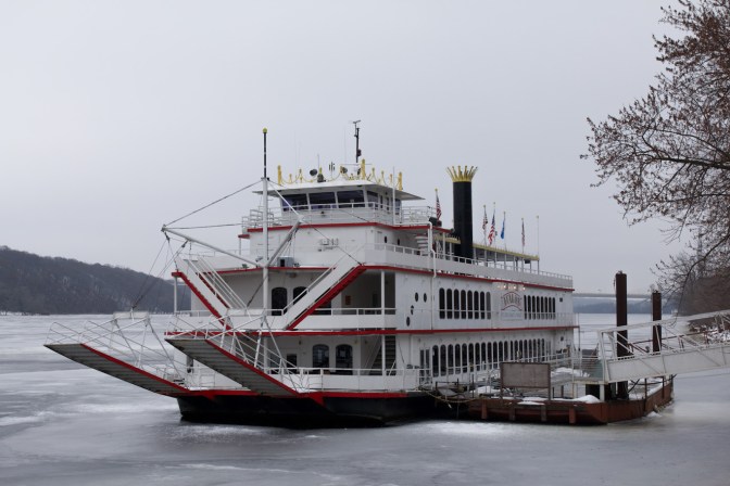 River steamboat docked along side of ice-covered St. Croix River.
