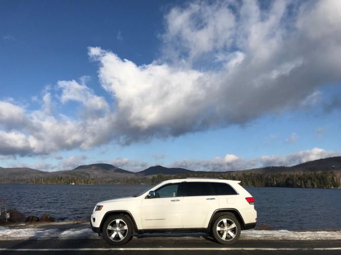 White Jeep Grand Cherokee in front of Blue Mountain Lake.